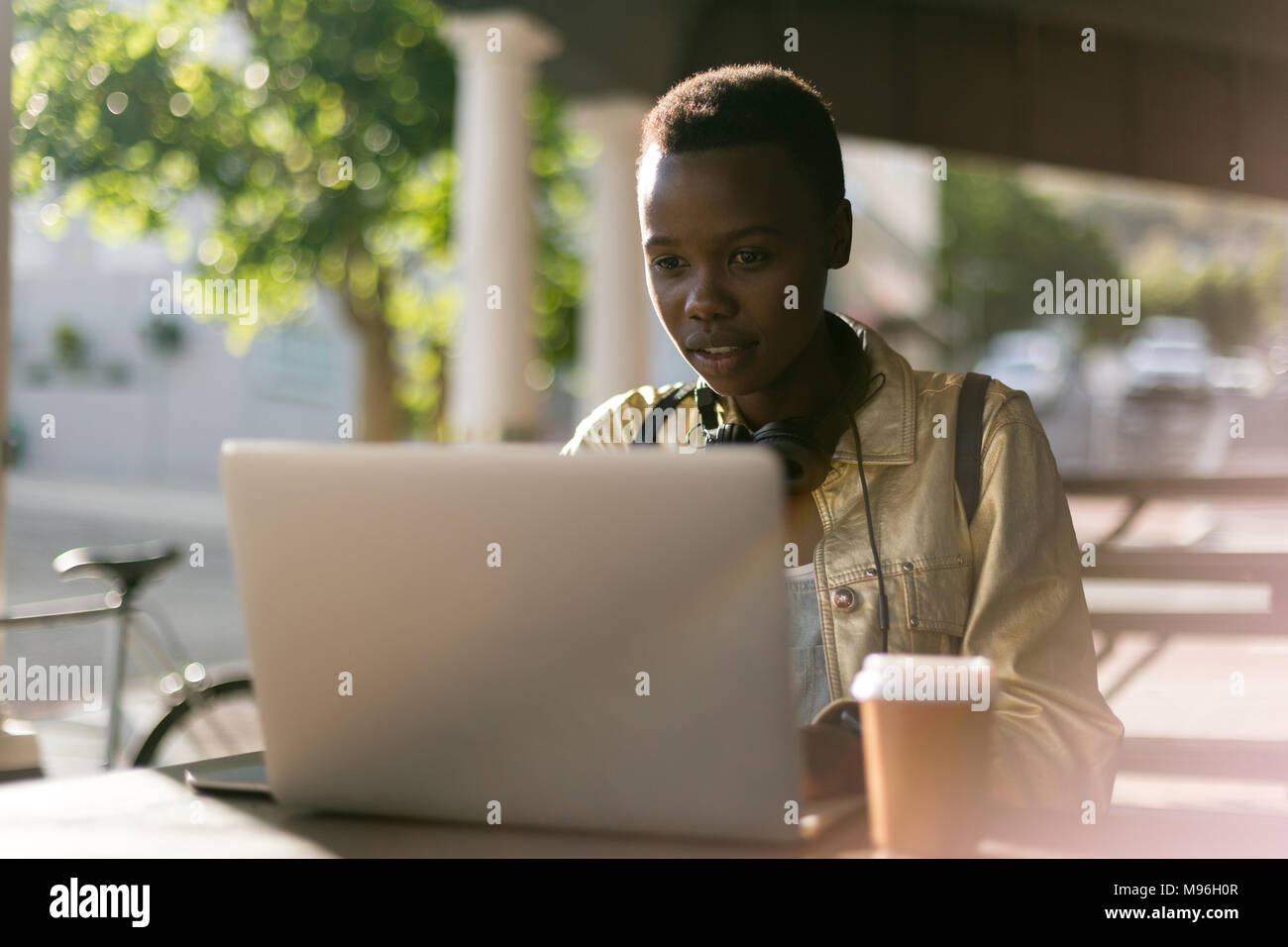 Woman using laptop in outdoor cafe Banque D'Images