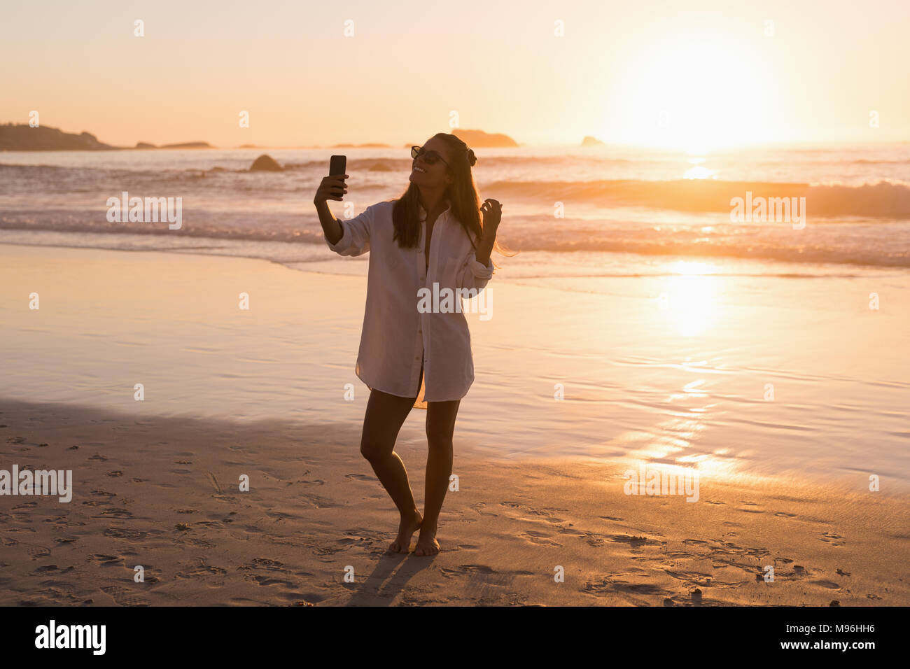 Woman with mobile phone selfies dans la plage Banque D'Images