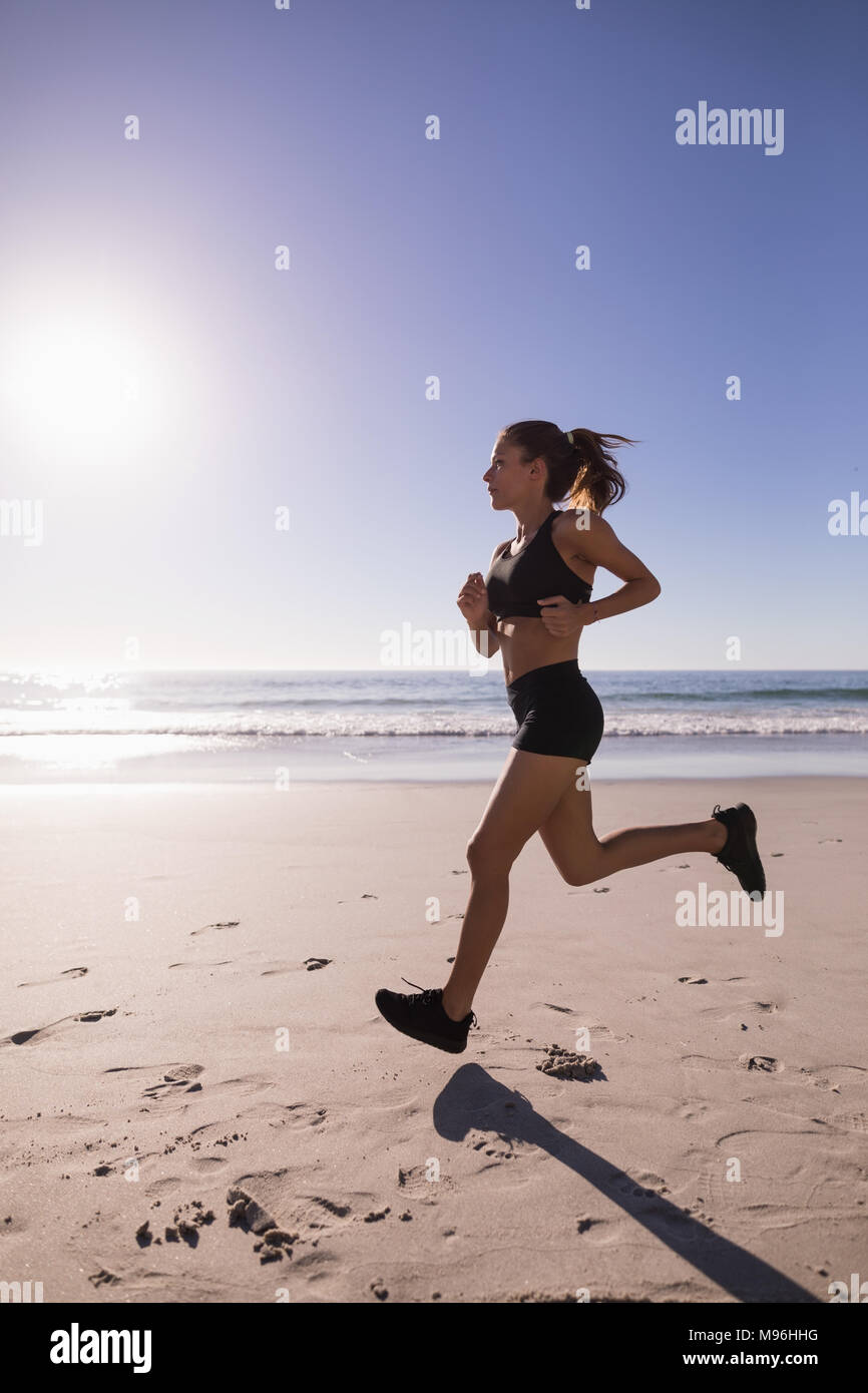Fit woman jogging sur la plage Banque D'Images