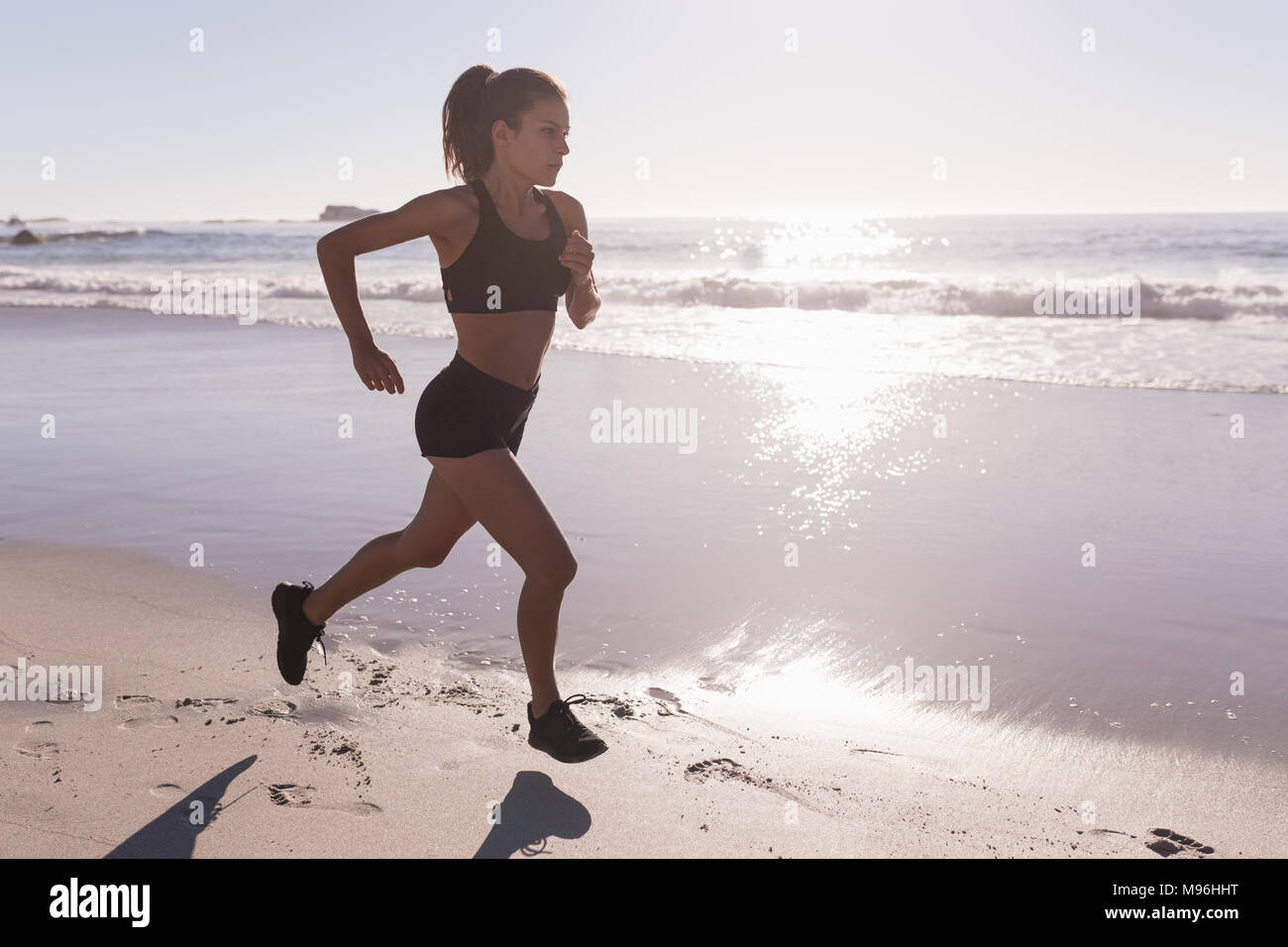 Fit woman jogging sur la plage Banque D'Images