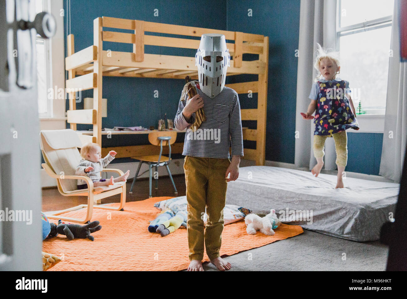 Garçon avec casque de chevalier debout dans la chambre Banque D'Images