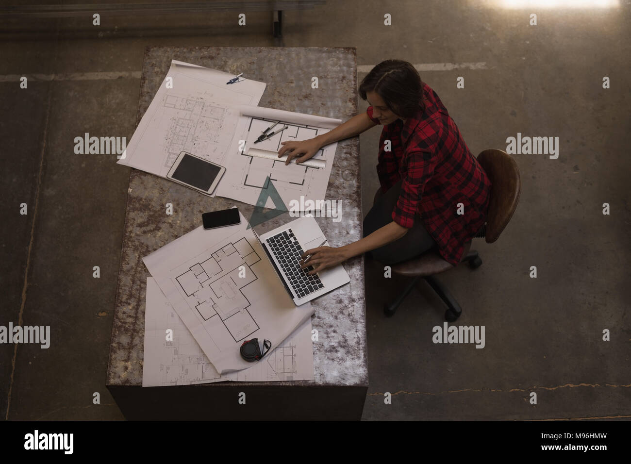 Soudeur femelle using laptop in workshop Banque D'Images