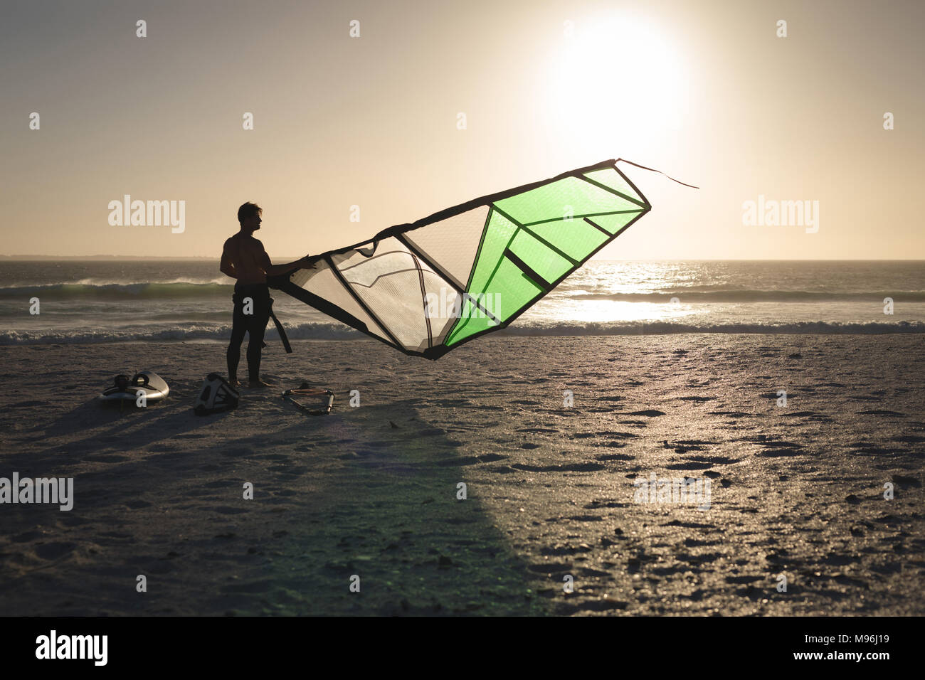 La préparation d'un kite surfeur mâle sur une plage Banque D'Images