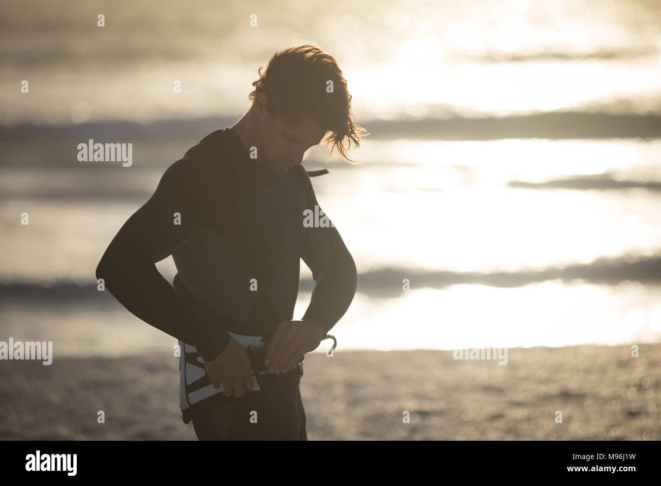 Homme portant des surfeurs kite harness sur la plage Banque D'Images