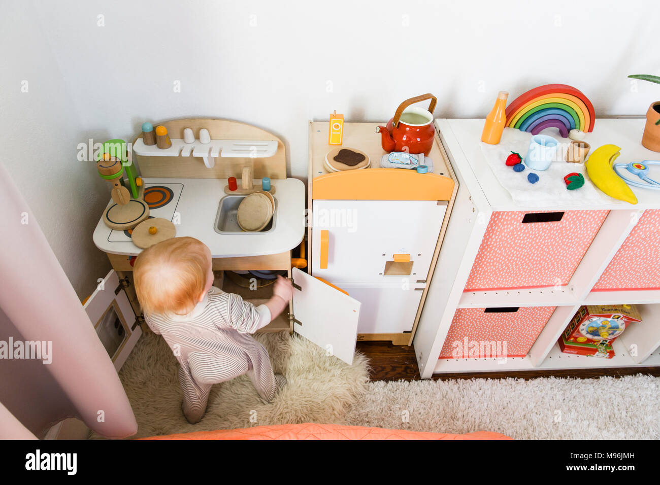 Bébé jouant avec set de cuisine en bois Banque D'Images