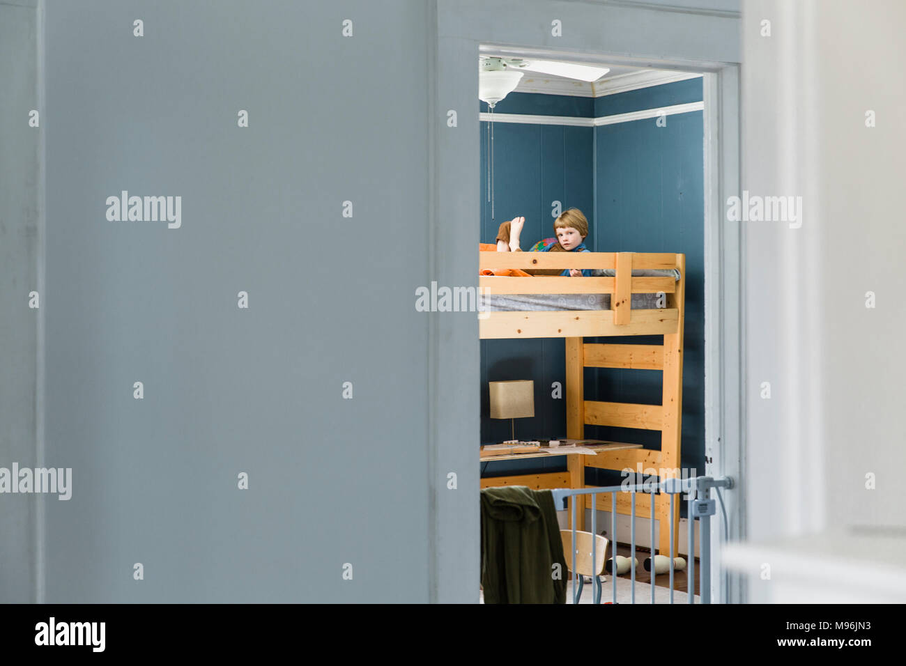 Garçon sur le dessus de lit superposé lecture Banque D'Images