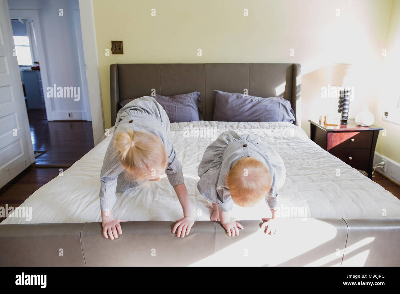 Girl et baby playing on bed Banque D'Images