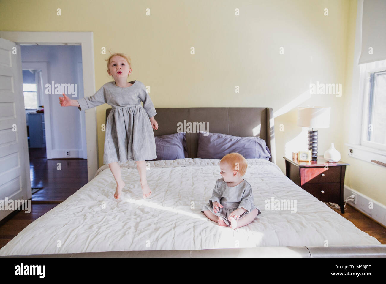 Girl et baby playing on bed Banque D'Images