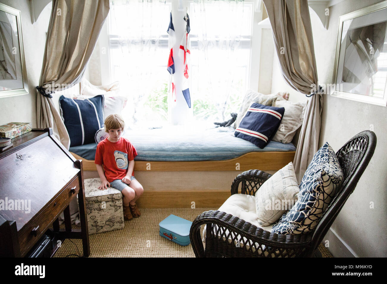 Garçon assis dans un style nautique chambres Banque D'Images