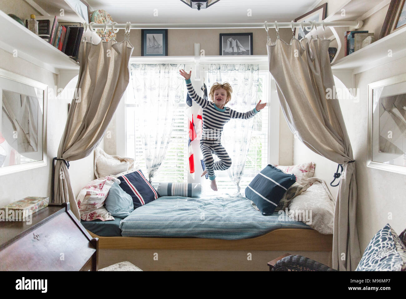 Boy jumping on bed Banque D'Images