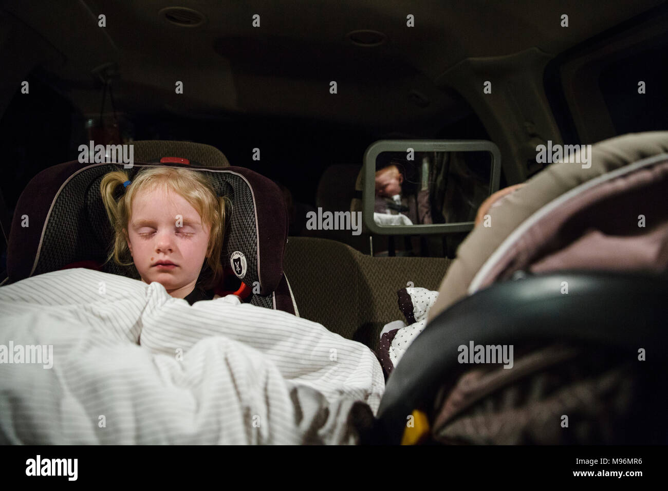 Deux enfants dormant dans des sièges de voiture Banque D'Images