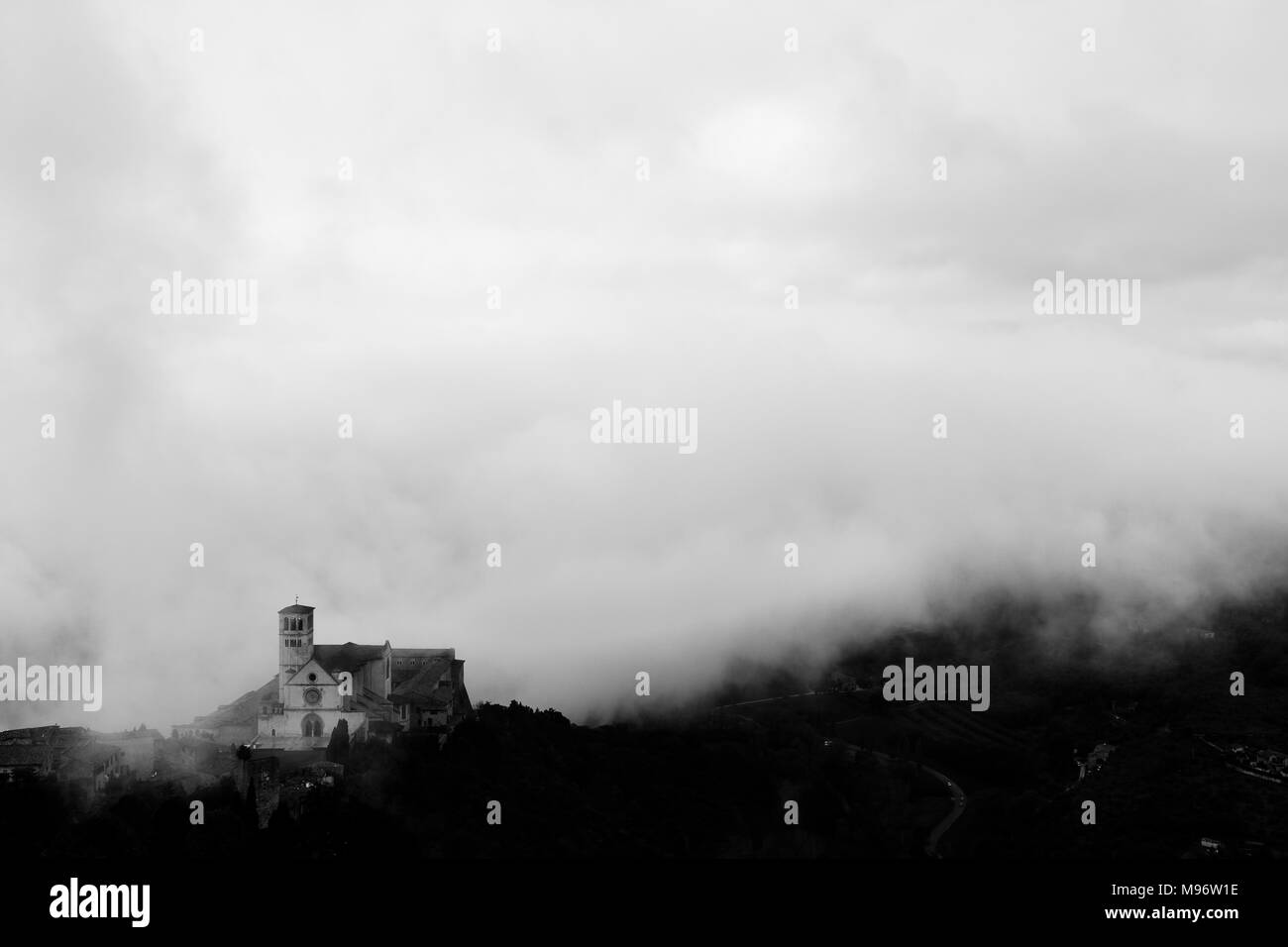 Voir l'église Papale de Saint François à Assise (Ombrie, Italie) au milieu de la levée du brouillard du matin Banque D'Images