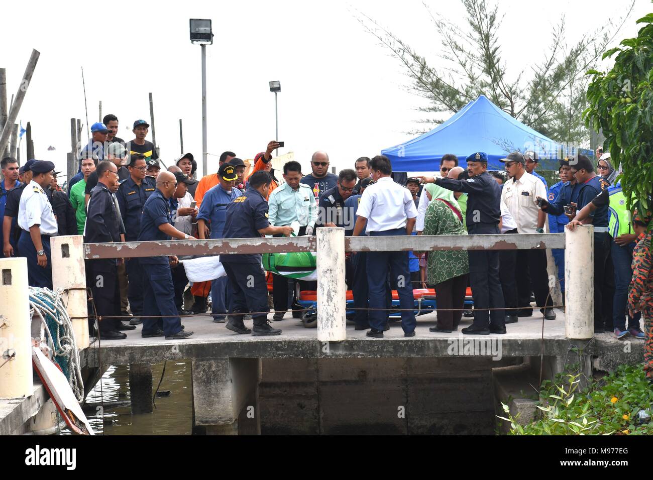 (180323) -- MUAR, 23 mars 2018 (Xinhua) -- Un marin chinois est transférée après qu'il a été sauvé d'un dragueur de sable a chaviré à Muar du sud de l'état malaisien de Johor, le 23 mars 2018. Deux chinois d'équipage ont été sauvés d'un dragueur de sable a chaviré dans les eaux près de la Malaisie le vendredi, comme les plongeurs ont poursuivi leurs recherches sous-marines pour les 12 autres. (Xinhua/Chong Voon Chung) (côté droit) Banque D'Images