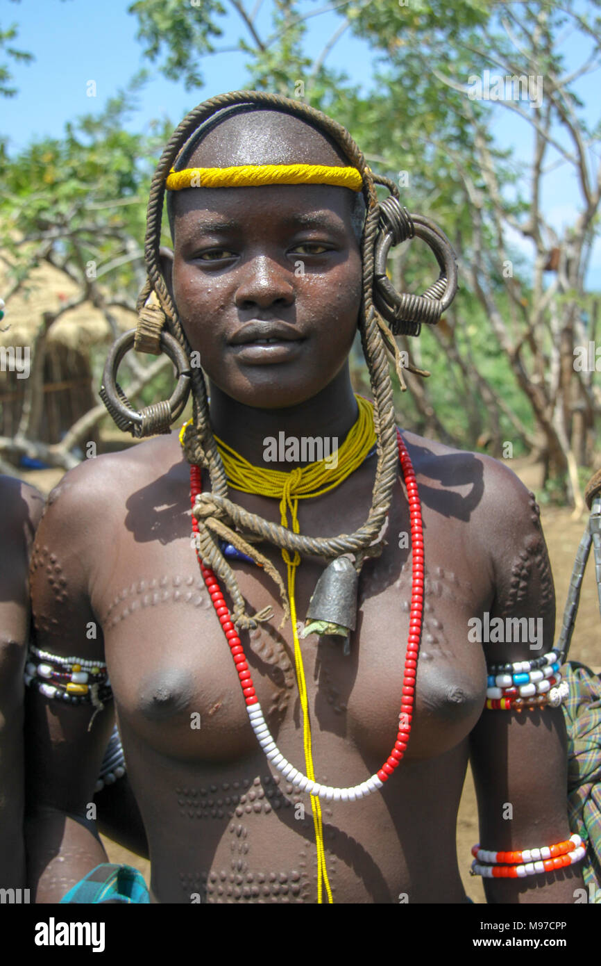 Dans la tribu Mursi Omom River Valley, de l'Éthiopie. Une jeune beauté avec tribeswoman cicatrices, la tribu Mursi est un groupe ethnique nomade d'éleveurs de bétail loca Banque D'Images