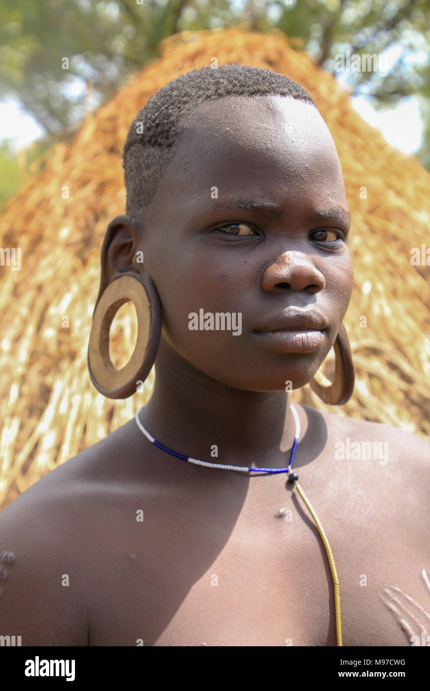 Dans la tribu Mursi Omom River Valley, de l'Éthiopie. Un jeune tribeswoman avec lobes allongés, la tribu Mursi est un éleveur de bétail nomades l ethnie Banque D'Images