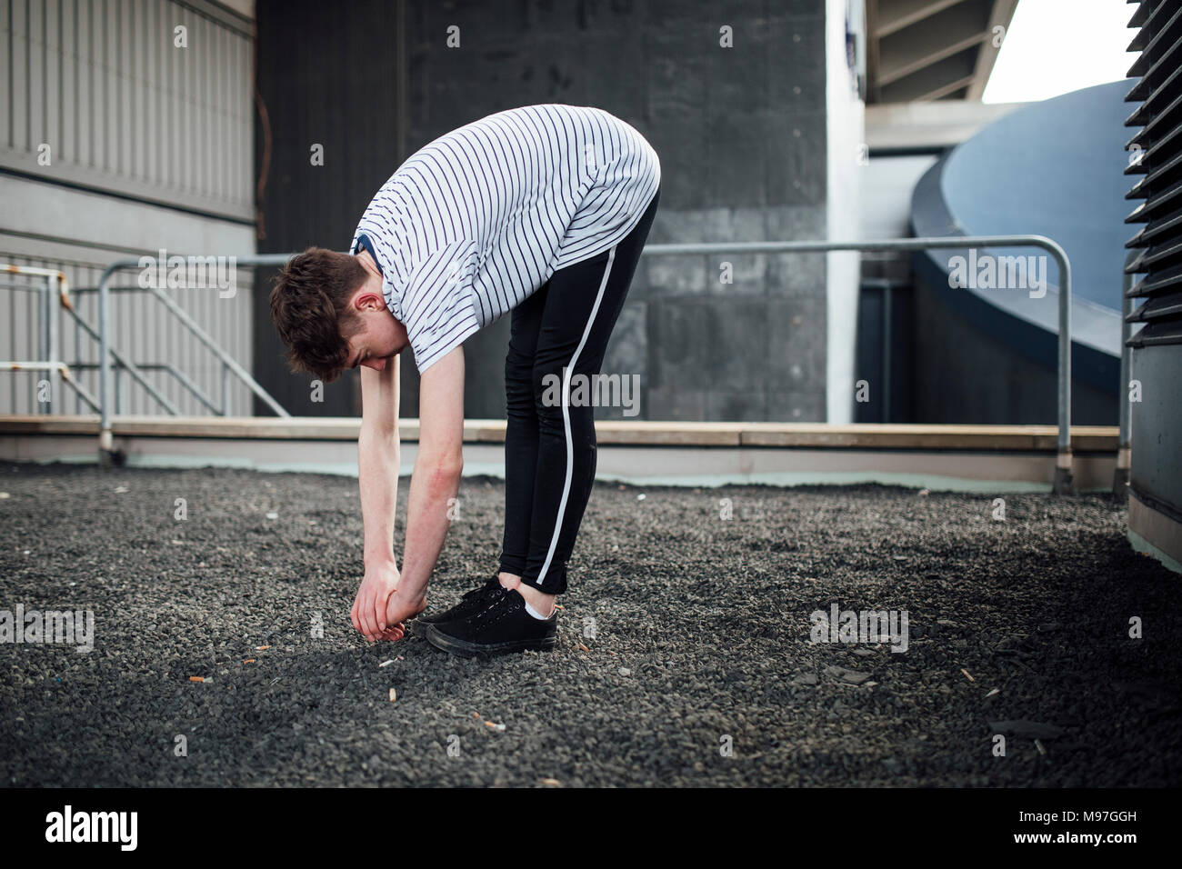 Freerunner s'étire sur un toit. Banque D'Images