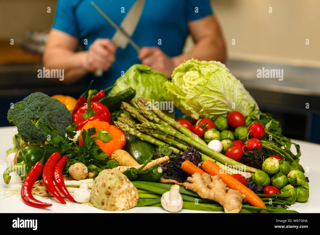 Homme avec une grande variété de légumes, prêts à être cuisinés Banque D'Images
