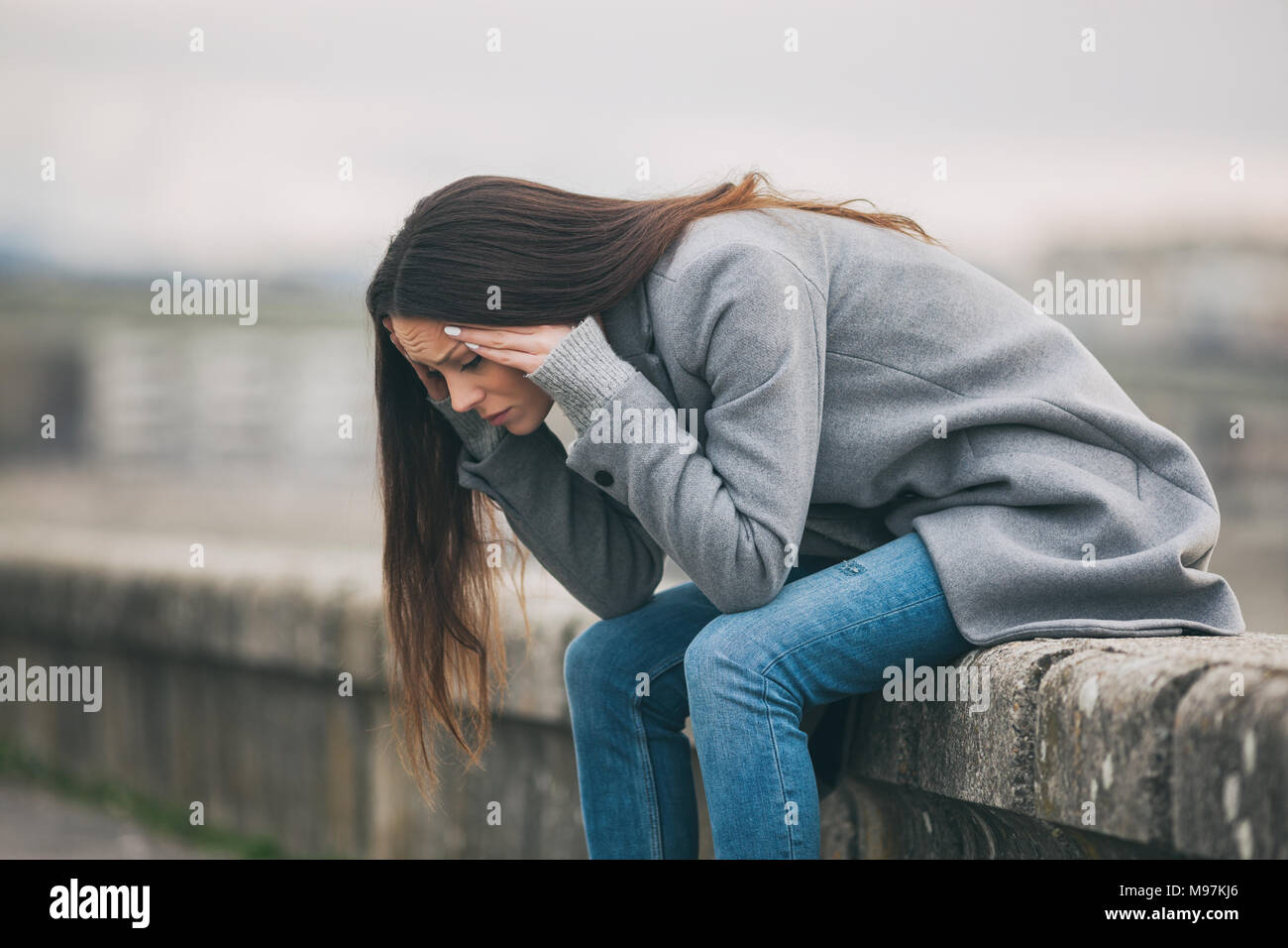 Jeune femme solitaire et déprimé est assis dans le chagrin. Banque D'Images