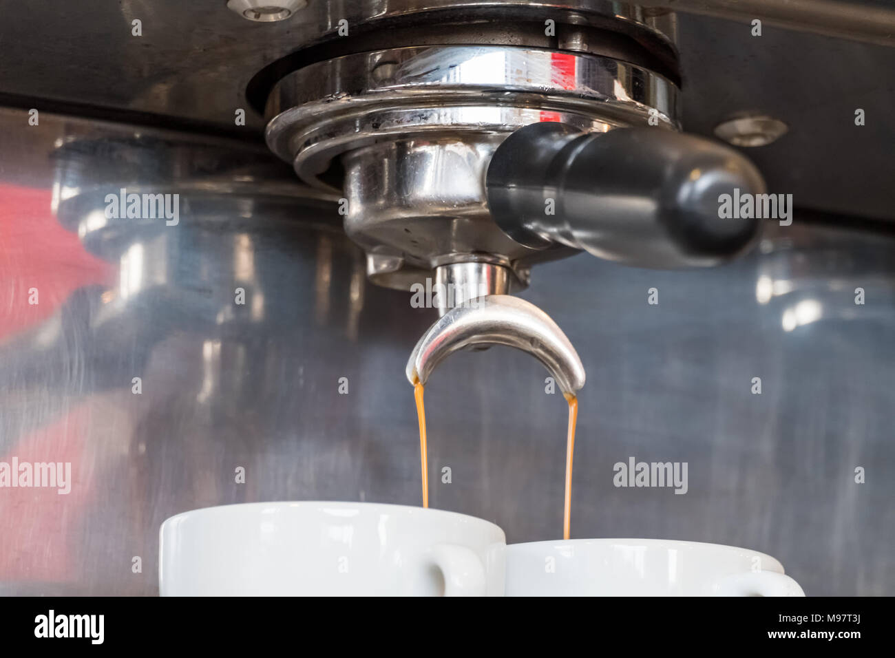 Des gouttes d'expresso frais portafilter de machine à café en tasse blanche Banque D'Images