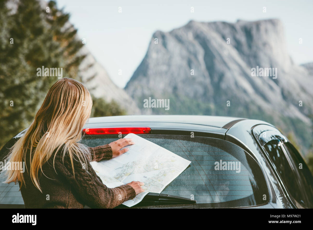 Femme avec la planification du voyage itinéraire en voiture de location avec road trip en Norvège carte de vie voyage vacances week-end aventure concept outdoor mountain vues Banque D'Images