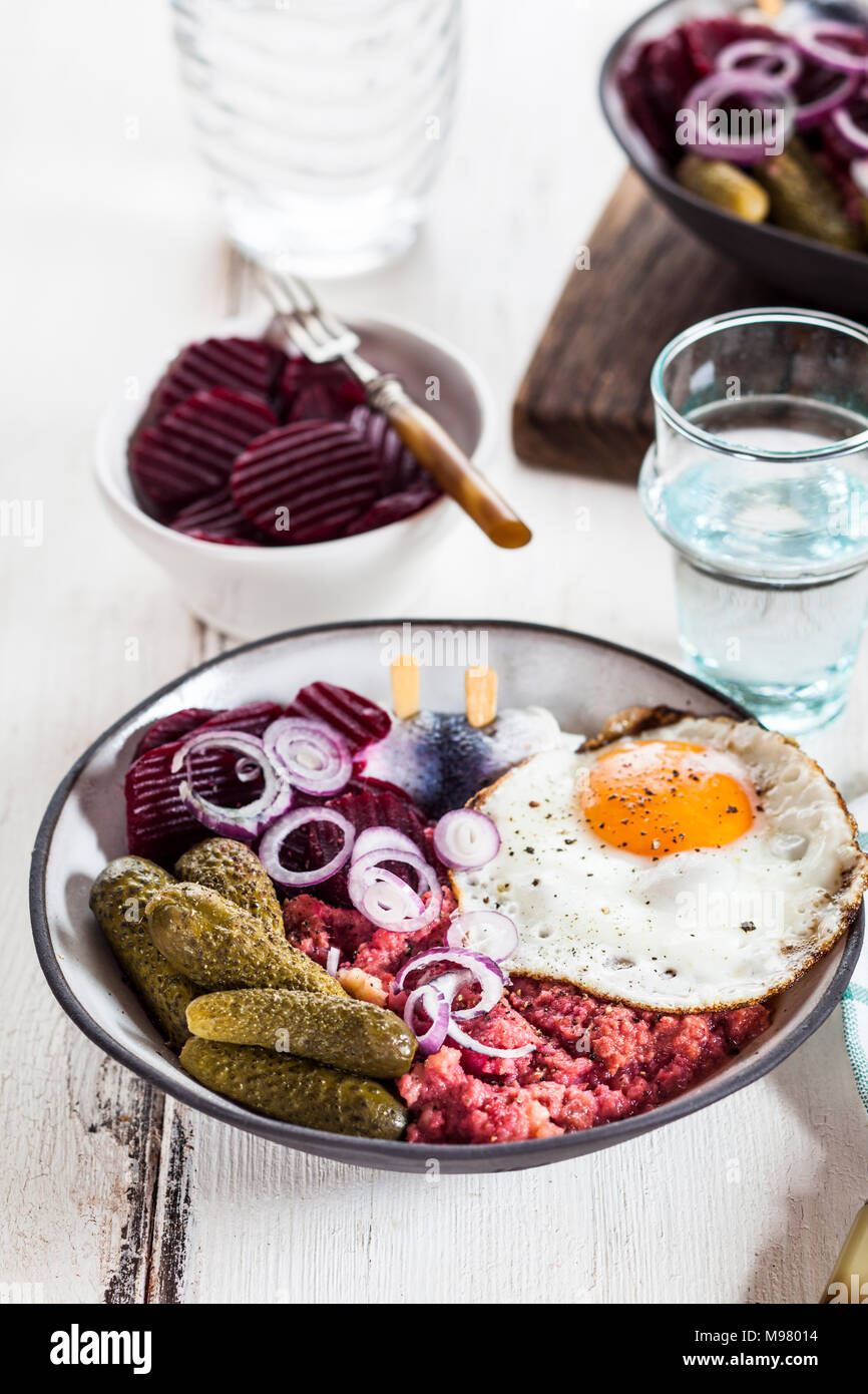 Labskaus, rollmops, cornichon mariné Salade, betterave, l'oignon et l'oeuf au plat Banque D'Images