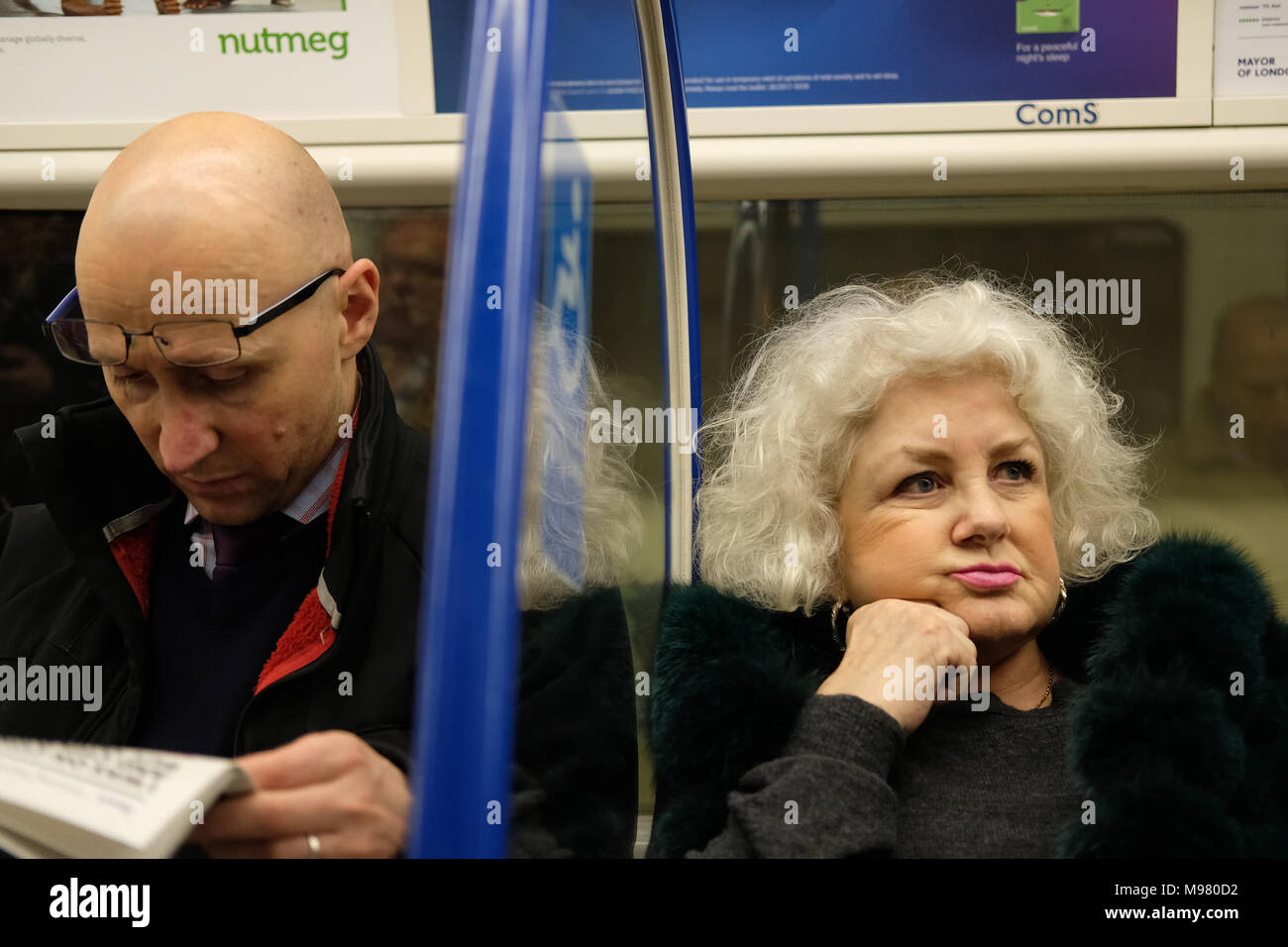 Un homme et une femme à côté de l'autre dans un train. Banque D'Images