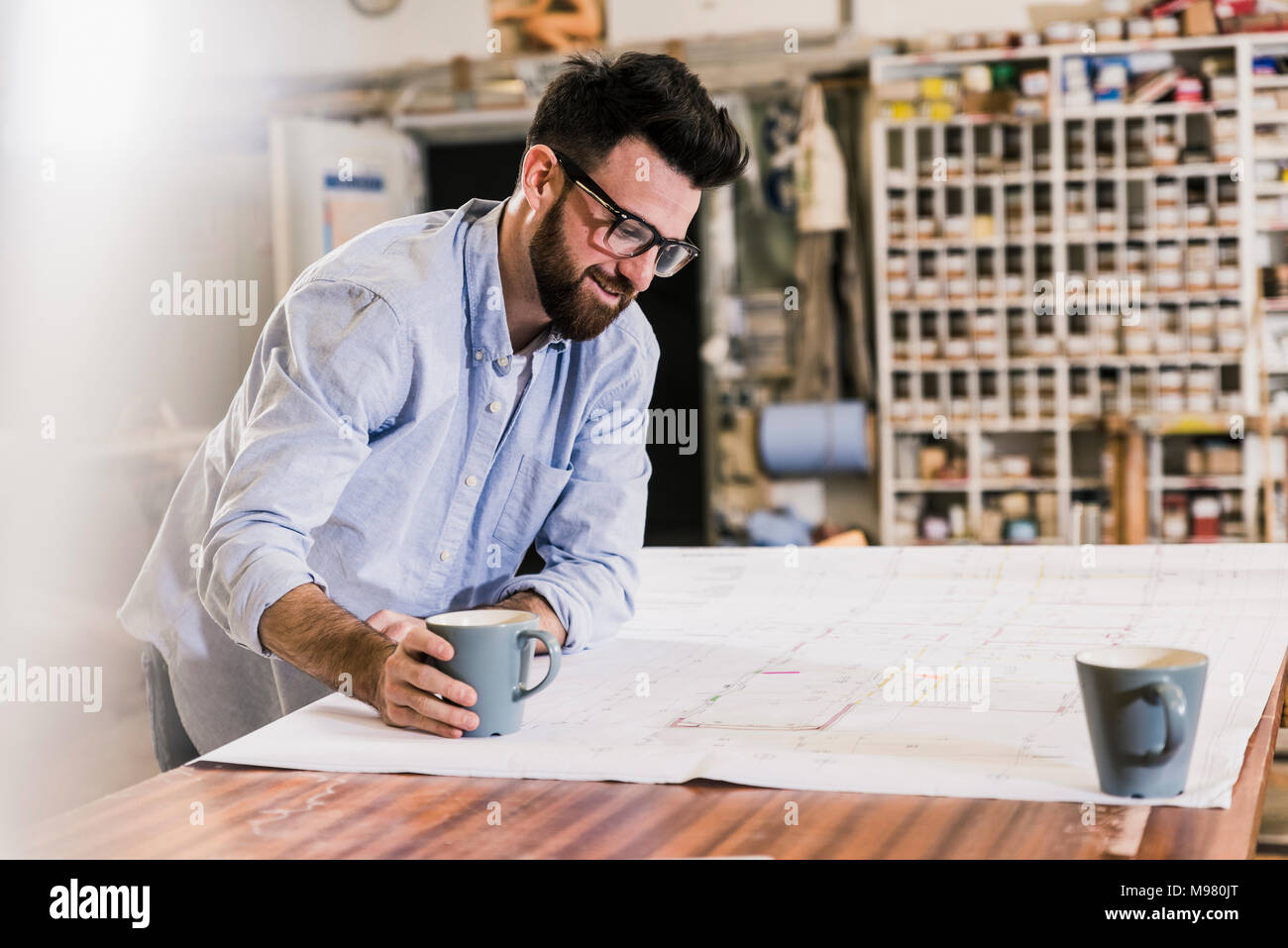 Smiling man looking at construction plan Banque D'Images