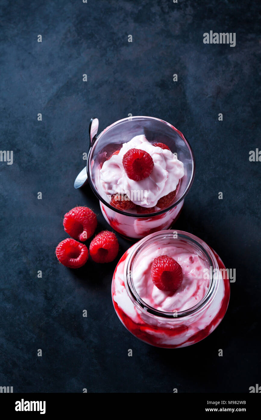 Peu de crème fouettée avec fraises et sauce aux fraises dans les verres Banque D'Images
