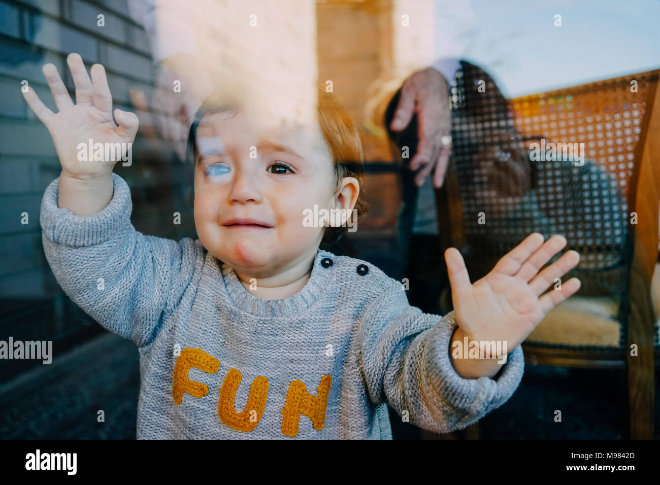 Bébé fille pleurer derrière la porte de verre Banque D'Images