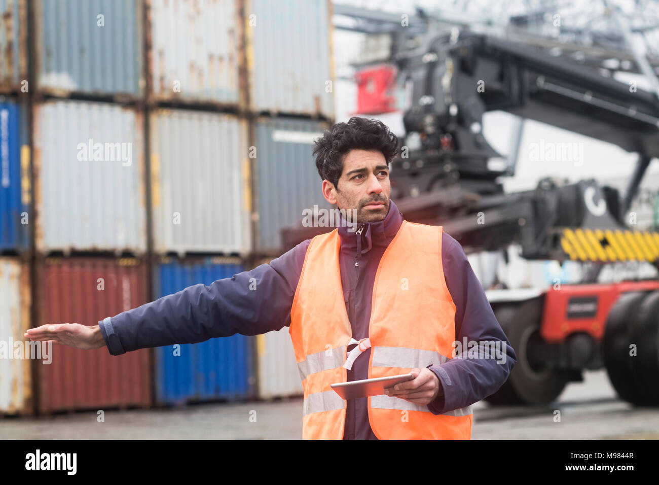 Man with tablet porter gilet réfléchissant au port à conteneurs Banque D'Images