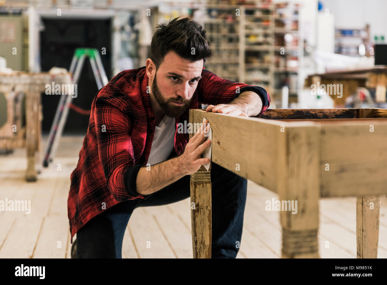 L'homme le traitement du bois en atelier avec le papier de verre Banque D'Images