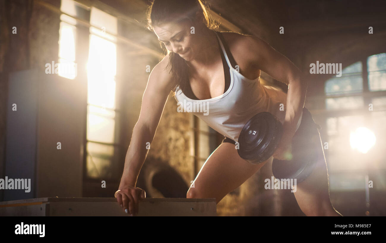 Femme athlétique solide n'appuyez sur banc d'haltère exercice dans le cadre de son contre fitness musculation Fitness Exercice. Banque D'Images