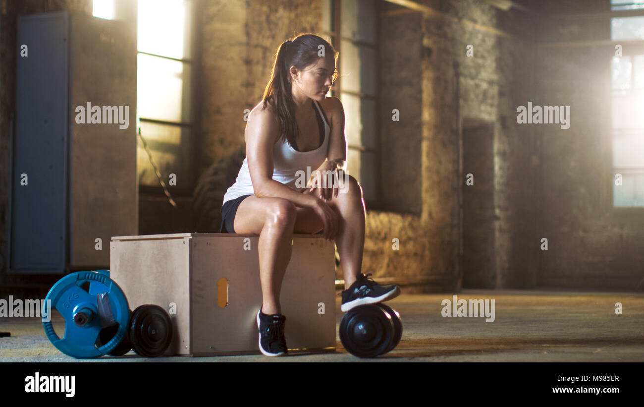 Belle femme athlétique se détend sur un banc après un Cross fitness musculation exercice de son sport favori. Banque D'Images