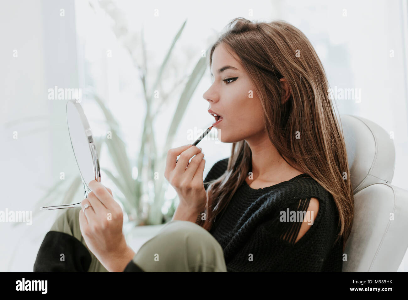 Portrait de jeune femme à l'aide d'un crayon à lèvres Banque D'Images