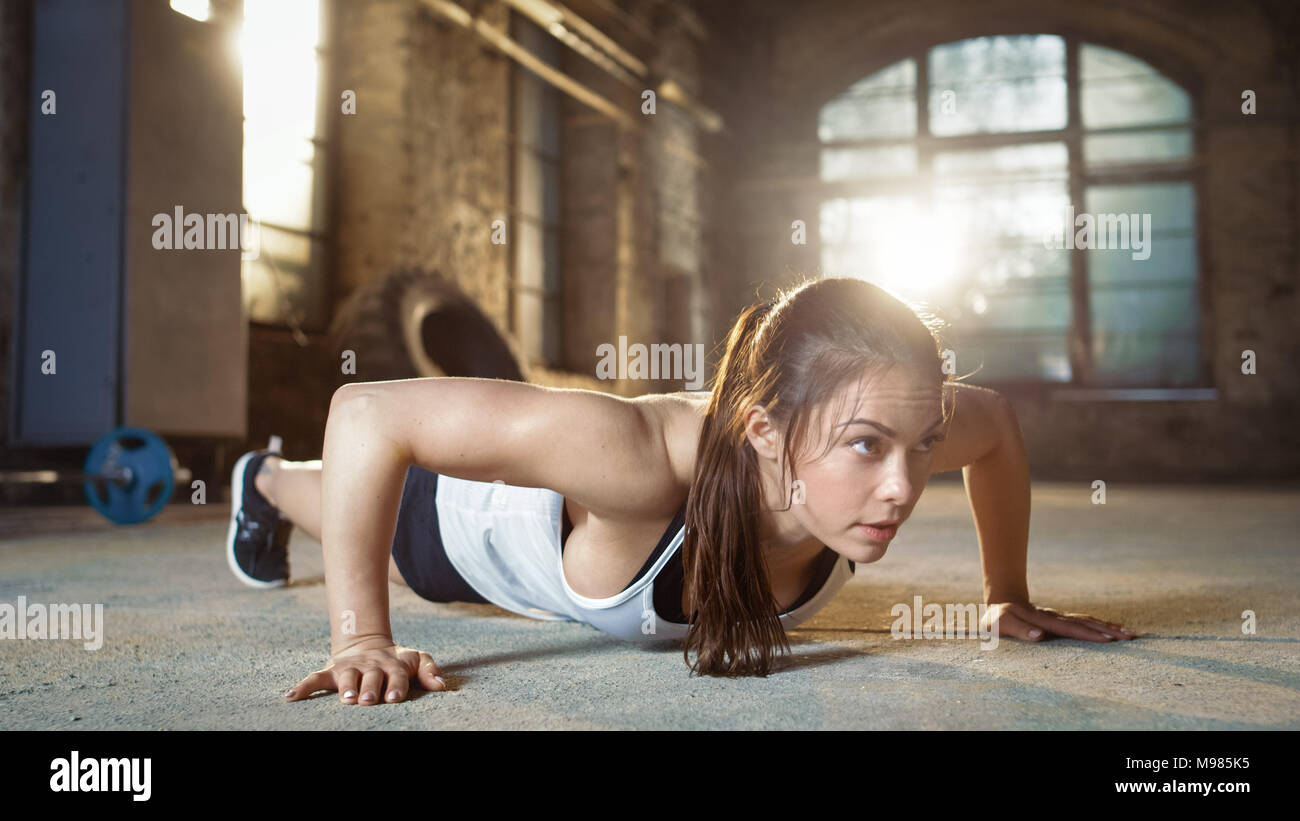 Belle femme athlétique n'Push-ups dans le cadre de son contre Fitness, Gym Bodybuilding Routine de formation. Banque D'Images