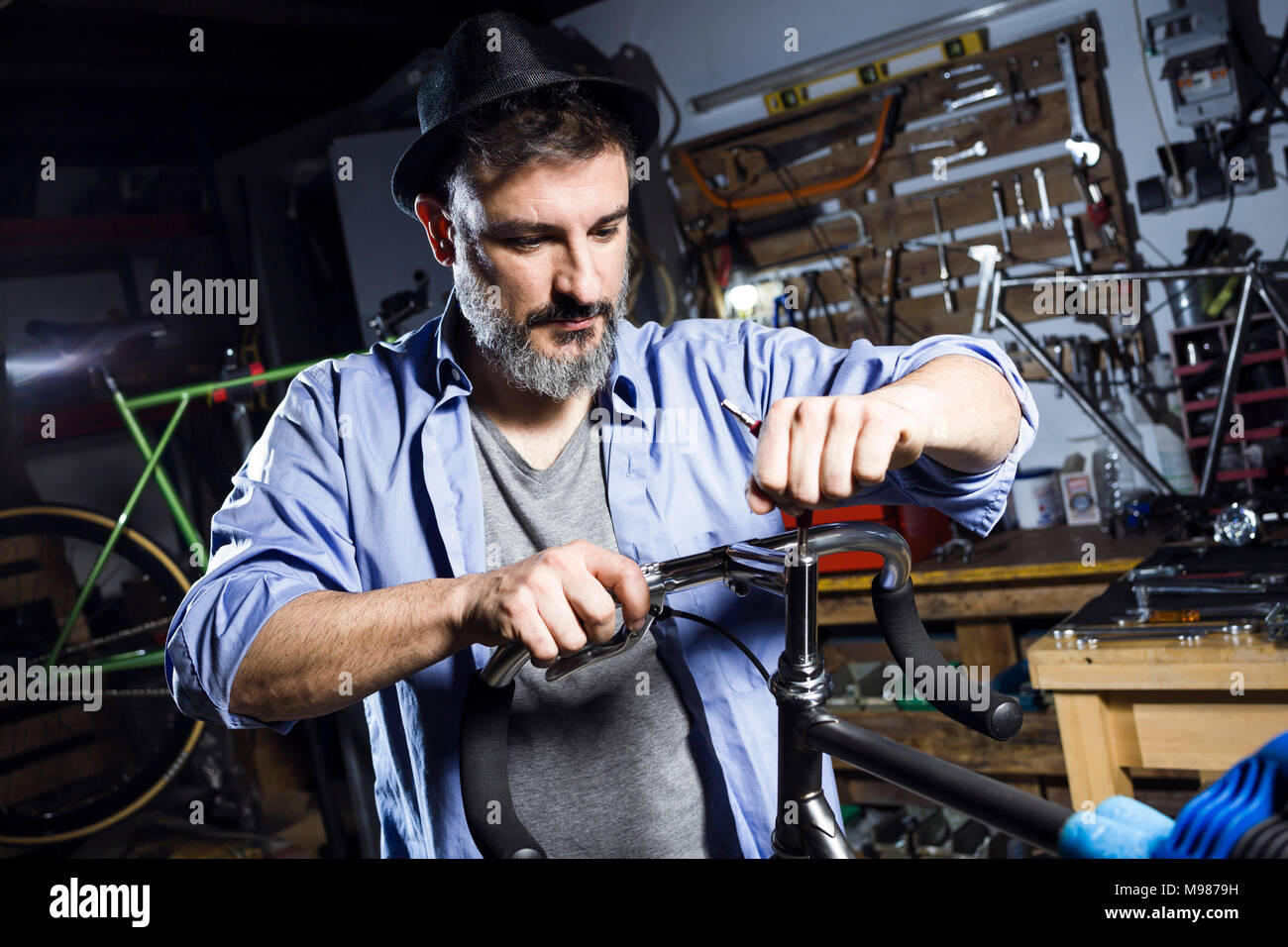 Man working on bicycle in workshop Banque D'Images