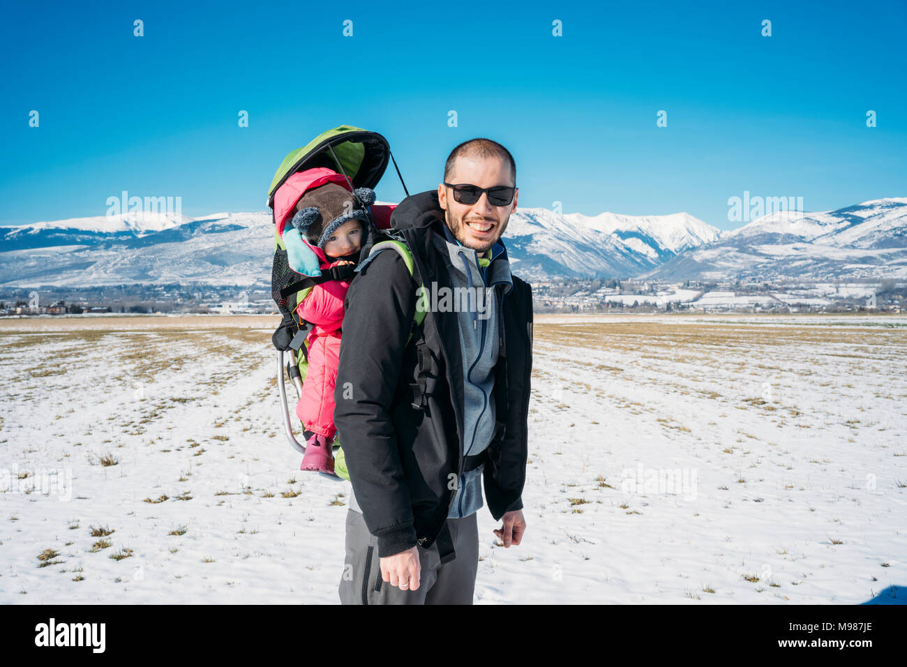 L'Espagne, Puigcerda, père avec bébé fille dans un sac à dos pour enfants au cours d'une randonnée de l'opérateur à l'hiver Banque D'Images