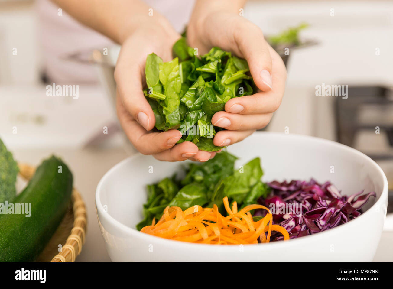 Mettre les mains de la laitue fraîche dans un bol avec des légumes Banque D'Images