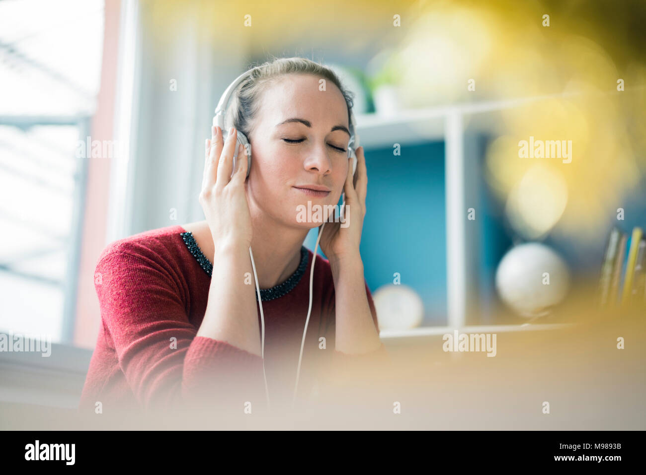 Portrait de femme avec les yeux fermés écoutant de la musique avec des écouteurs Banque D'Images