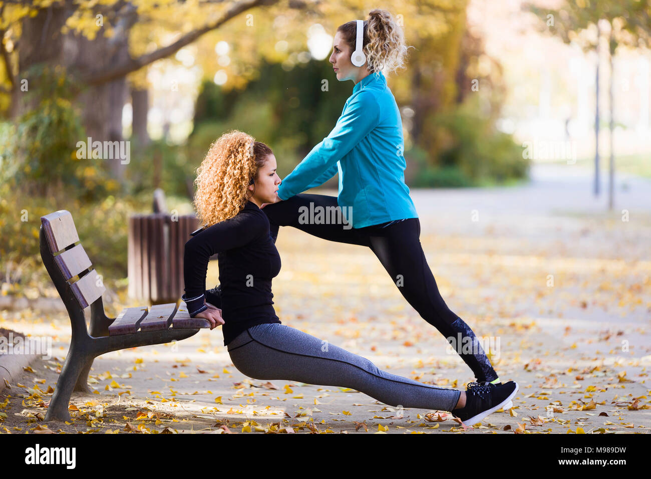 Deux jeunes femmes sportives stretching en park Banque D'Images