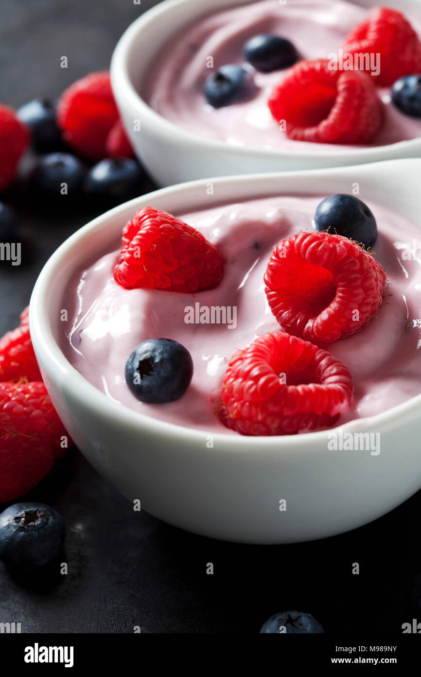 Deux bols de yaourt aux fruits avec des bleuets et framboises Banque D'Images