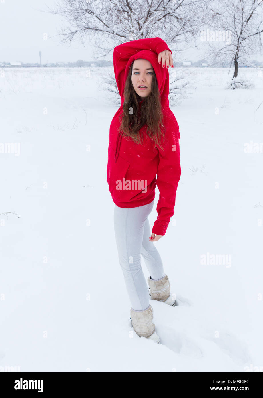 Une jeune femme d'un chandail bleu et blanc short jeans se dresse contre  l'arrière-plan d'hiver Photo Stock - Alamy