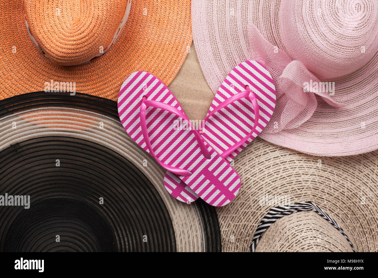 Jeu de plage, quatre beaux chapeaux et des chaussons rose. Vue de dessus Banque D'Images