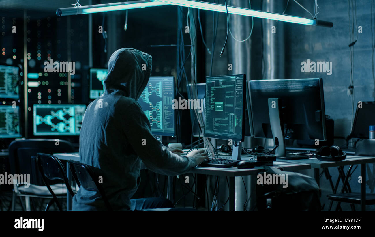 Hacker à capuchon en utilisant son comuter avec différentes informations pour s'introduire dans les serveurs de données d'entreprise et les infecte avec le virus. The Hideout Place. Banque D'Images
