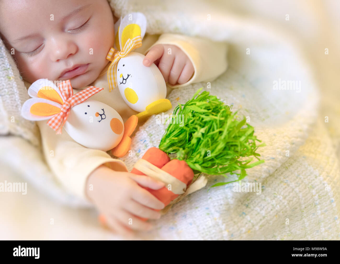 Joyeuses pâques, portrait d'un mignon petit bébé dormir à la maison avec ses jouets, oeufs de Pâques décorés lapins, calme jolie sieste enfant Banque D'Images