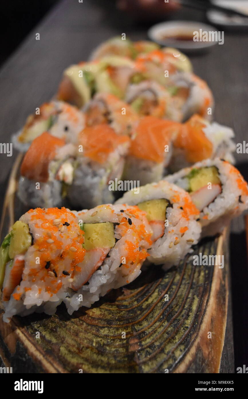 La nourriture japonaise. Close up de belle présentation d'un rouleau de maki sur un plateau en bois. Banque D'Images