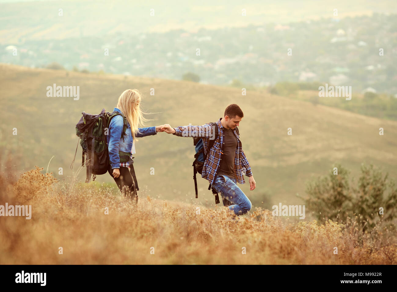 Un jeune couple de touristes avec des sacs à dos sont la marche dans la nature. Banque D'Images