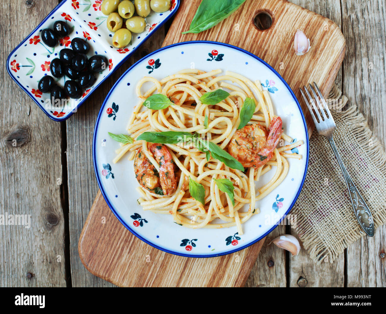 Spaghetti au pesto pâtes rÐ¾ssÐ¾, crevettes, le basilic et l'ail sur un fond de bois. Selective focus, vue du dessus. Banque D'Images