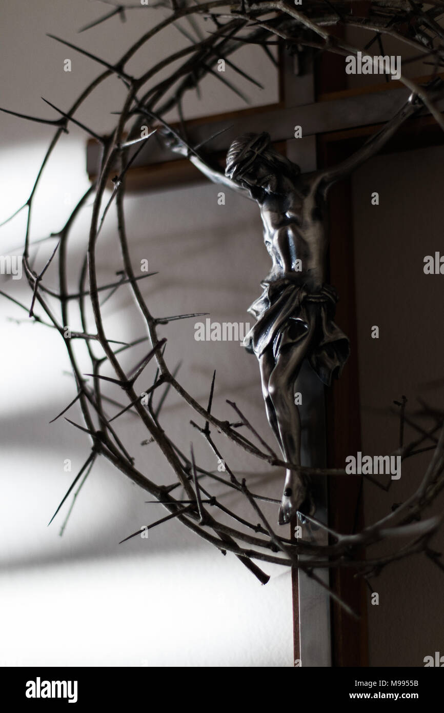 Couronne d'épines et crucifix dans l'éclairage dramatique. Banque D'Images