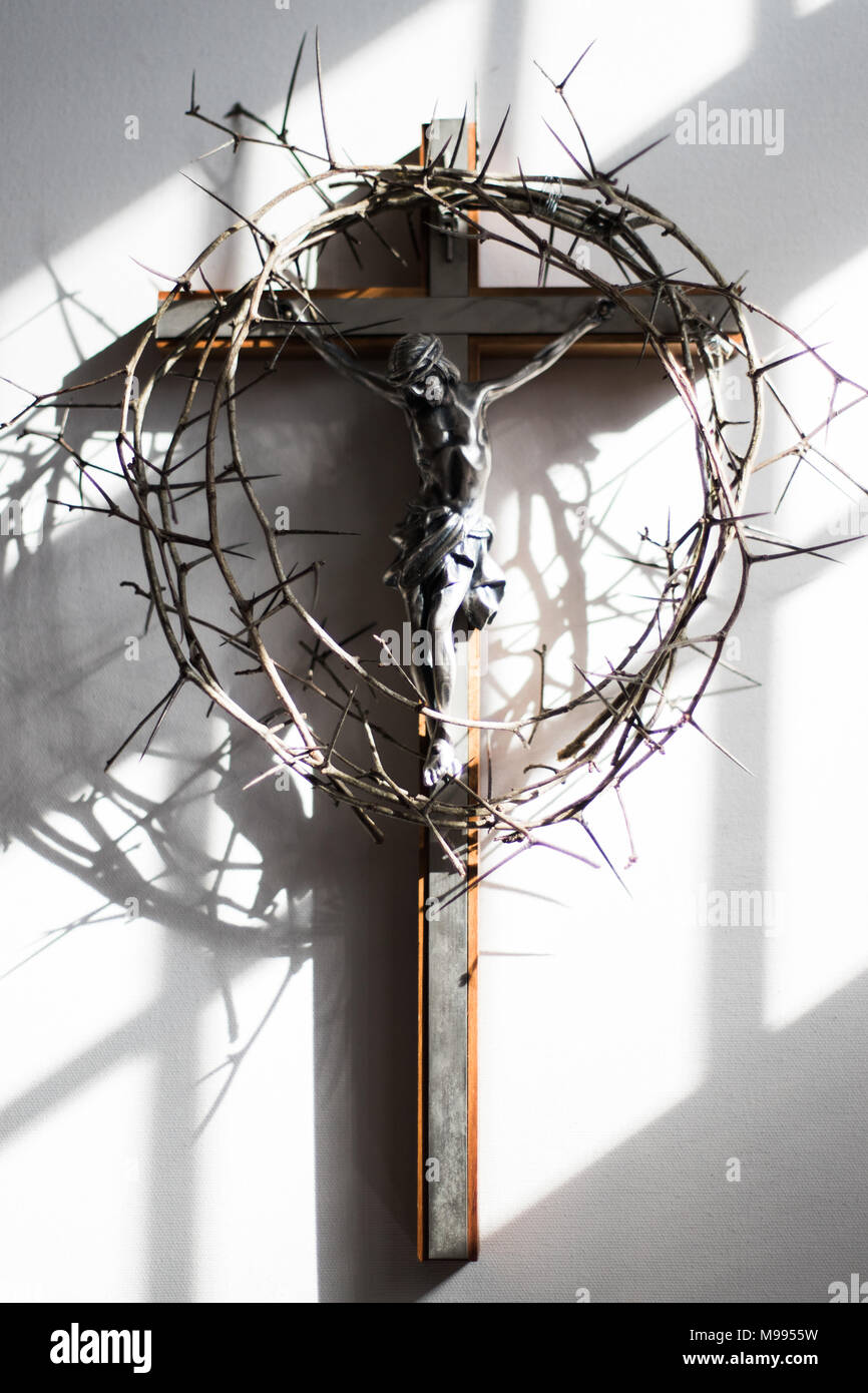 Couronne d'épines et crucifix dans l'éclairage dramatique. Banque D'Images